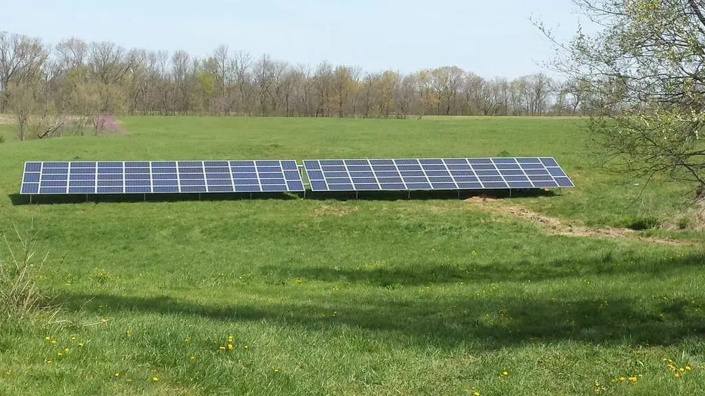 Two solar panels in a grassy field.